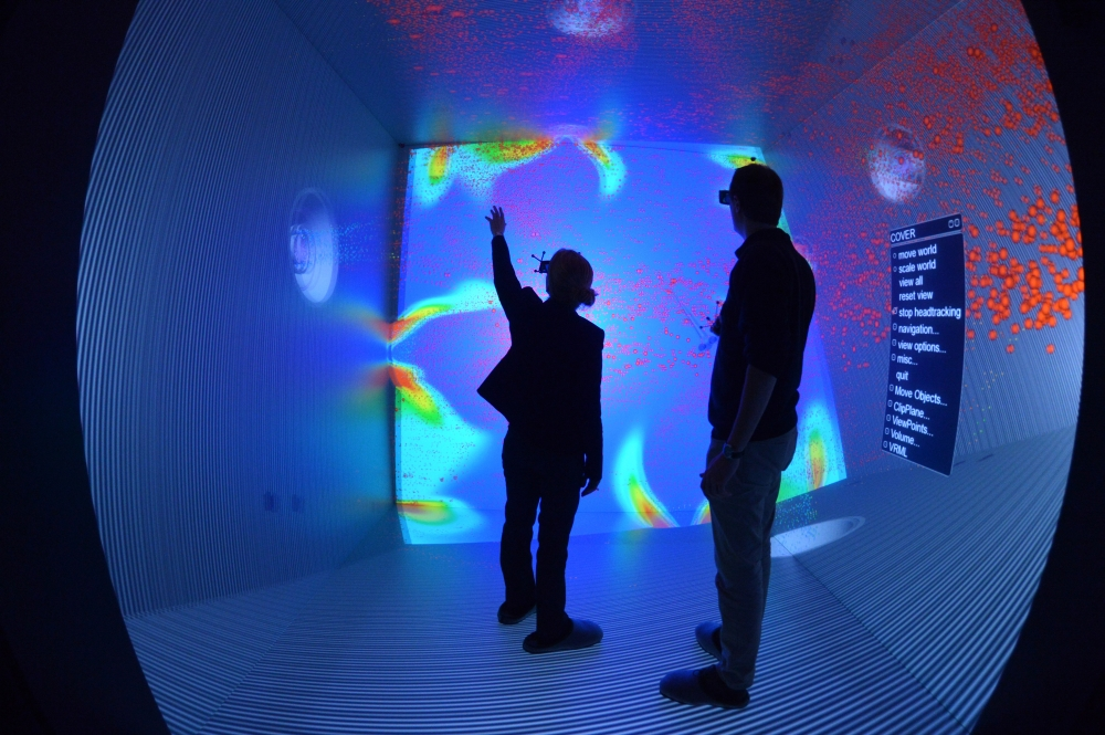 Zwei Menschen mit VR-Brillen in einem blau ausgeleuchteten Raum.