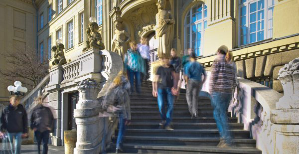 People on stairs leading to a baroque building