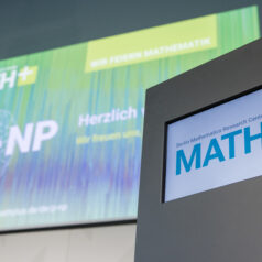 A screen with a podium with MATH+ logo